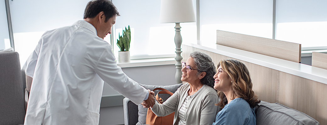 Image of a senior woman and her daughter meeting with a hearing care professional